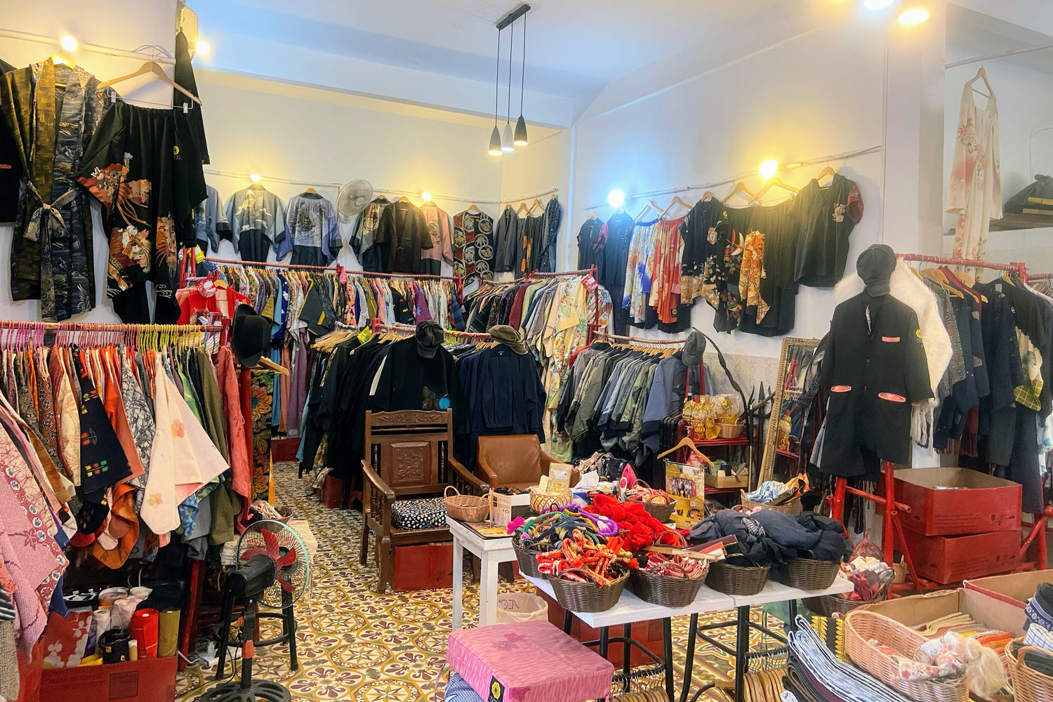 Interior view of the TATZU atelier in Phnom Penh, displaying rows of vintage kimono fabrics and remake garments.
