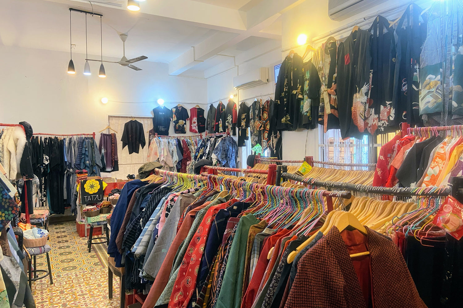 Wide-angle shot of the TATZU atelier showcasing kimono stock, custom pieces, and workspace atmosphere.